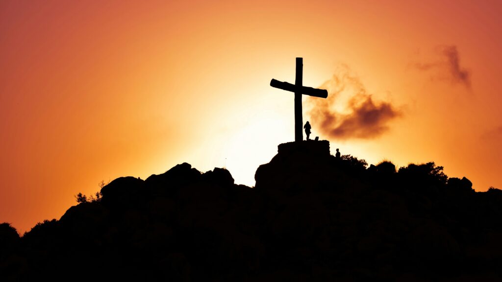 pexels-photo-415571-415571-1 Majestic silhouette of a cross on a hill during a vivid sunset, symbolizing spirituality.