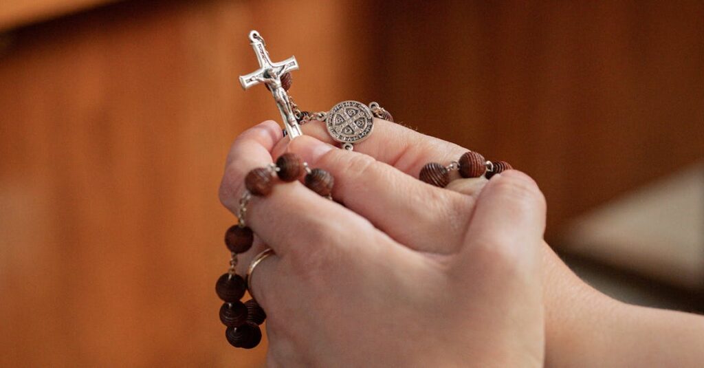A close-up of hands holding a rosary, reflecting faith and devotion.