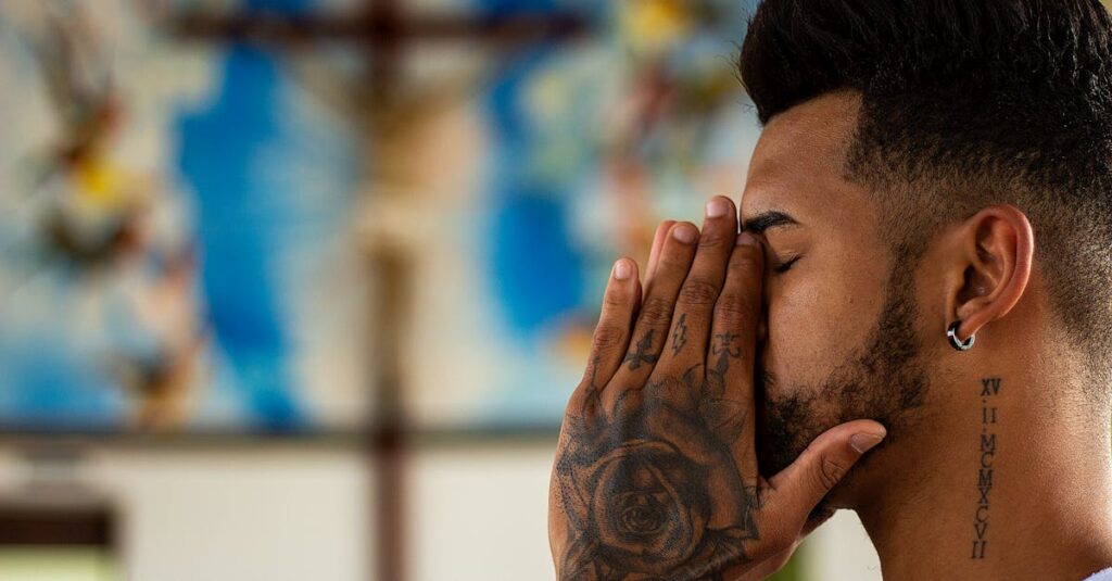 pexels-photo-1309052-1309052 A man with tattoos prays inside a church, capturing a moment of reflection and spirituality.