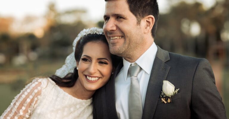 Charming outdoor wedding portrait capturing the joy of a newlywed couple embracing with smiles.
