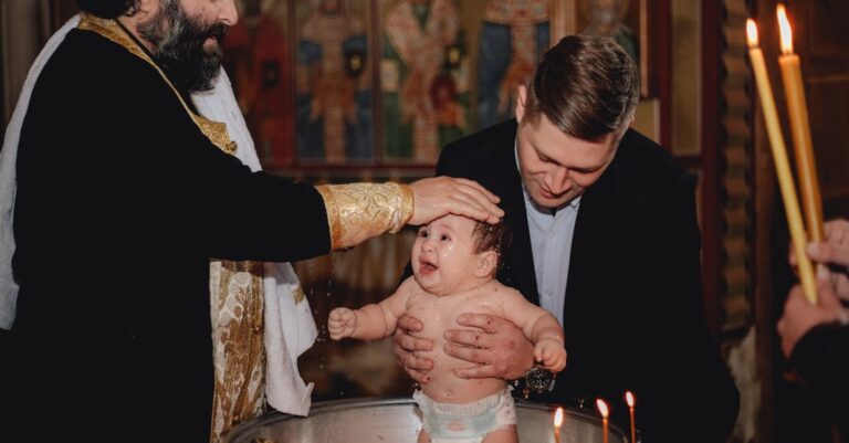 A priest performs a traditional baptism, blessing a baby in a church setting.