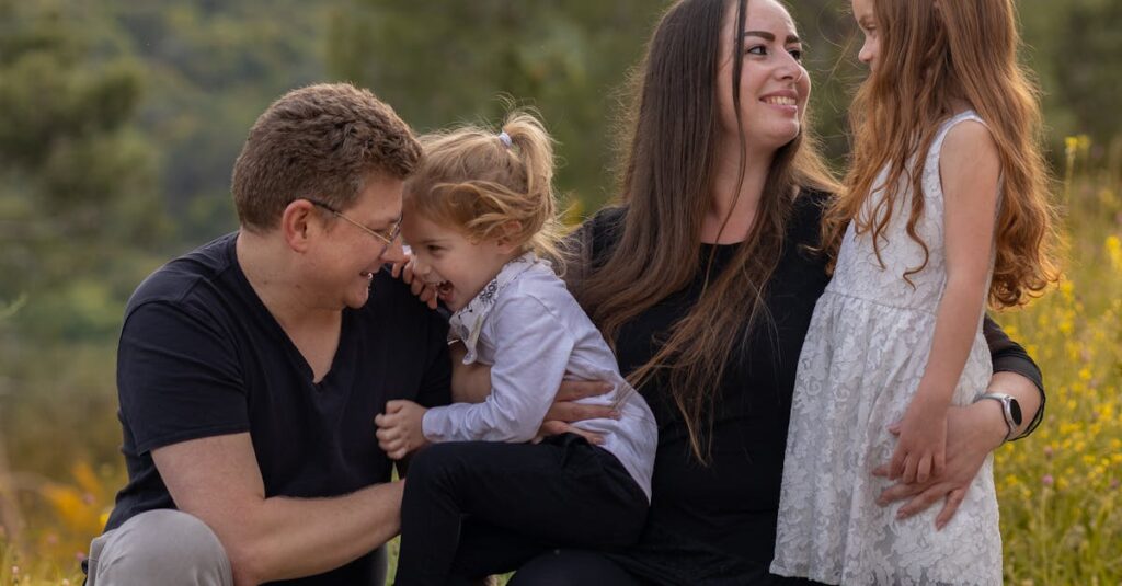 A joyful family enjoying a moment outdoors with their daughters.