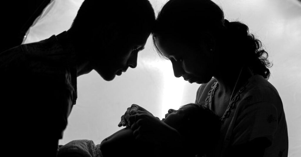 A touching silhouette of parents lovingly holding their newborn baby.