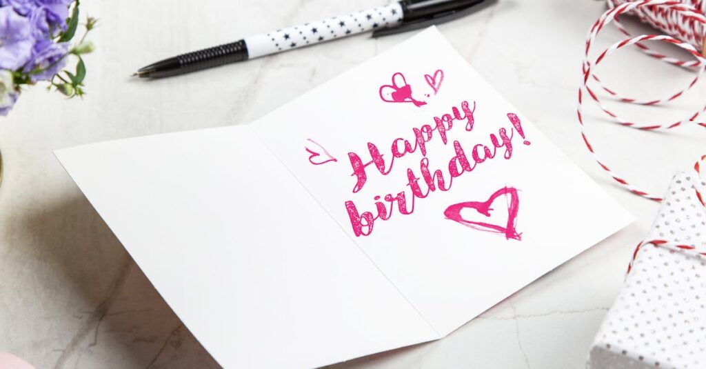 A vibrant birthday card with heart illustrations, surrounded by a pen, flowers, and gift wrap.