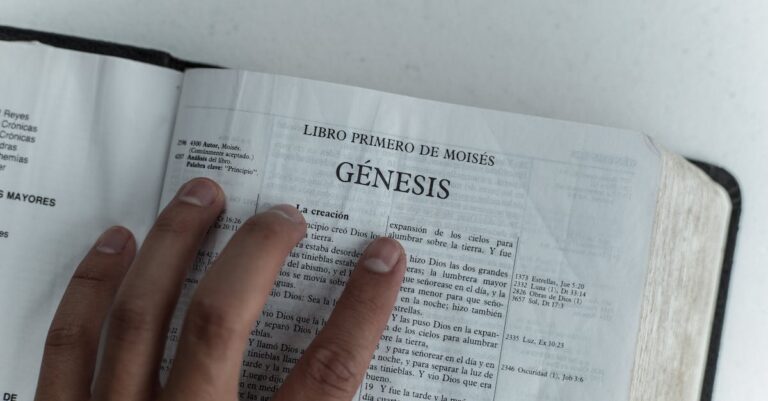 Close view of Genesis chapter in Spanish Bible, hand touching page.