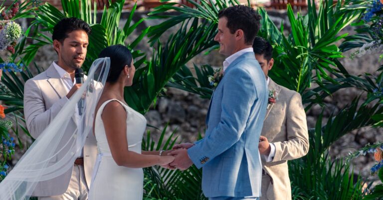 Bride and groom exchanging vows outdoors in a lush, tropical setting.