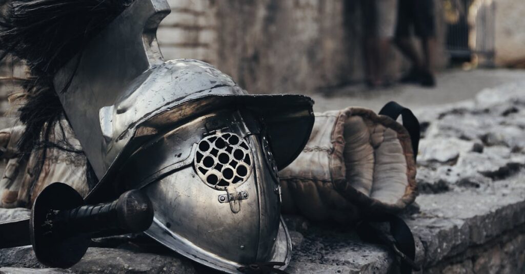 A medieval armor helmet, sword, and glove against a stone wall depicting historical combat gear.