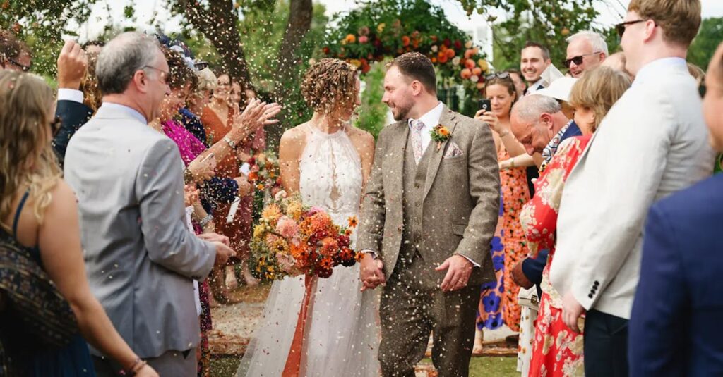 Couple celebrates outdoor wedding in England with family and friends.