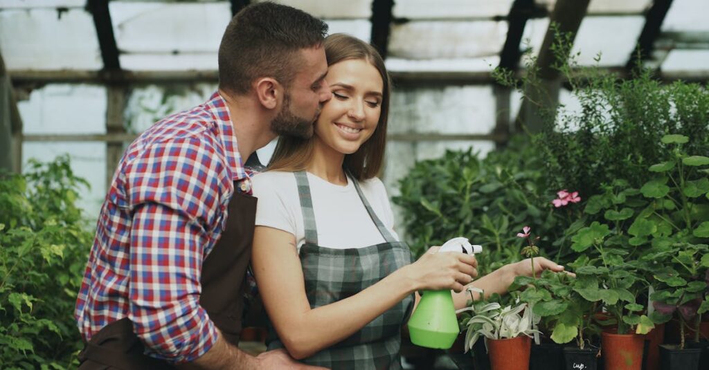 Couple joyfully caring for plants in greenhouse, romantic interaction.
