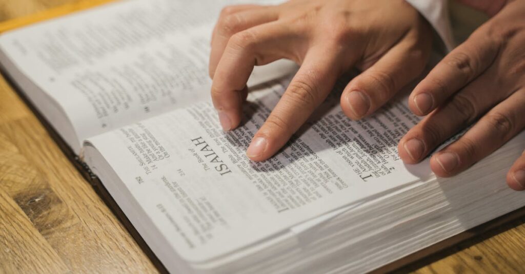 Close-up of hands reading a Bible, focusing on Isaiah passage, in an intimate indoor setting.
