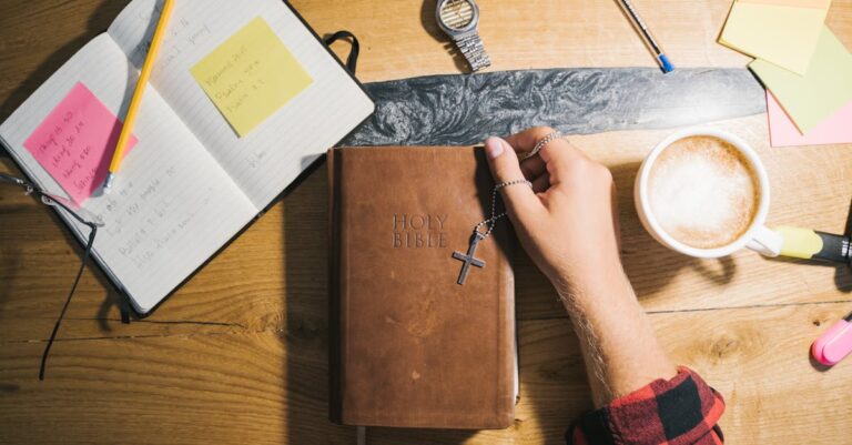 Top view of Bible study setup with coffee, notes, and wooden table.
