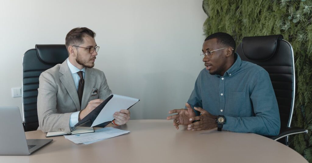 pexels-photo-5439447-5439447 Two businessmen engaged in a discussion during a job interview in a contemporary office environment.
