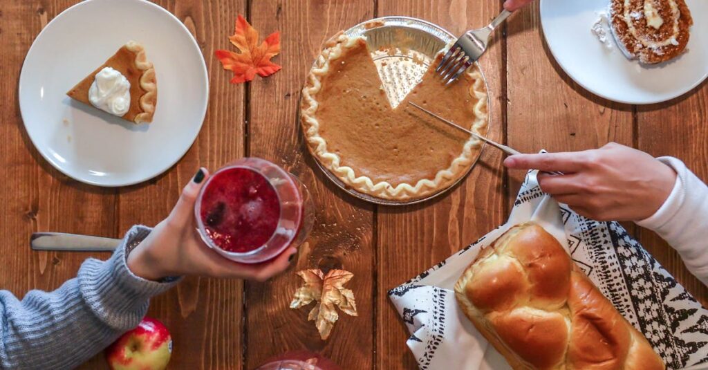 Cozy autumn table setting with pumpkin pie, bread, and drinks. Perfect for Thanksgiving vibes.