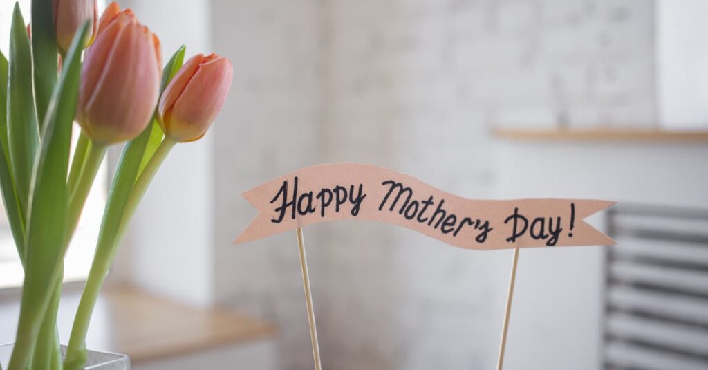 A beautiful arrangement of pink tulips with a 'Happy Mother's Day' sign indoors, perfect for celebration.