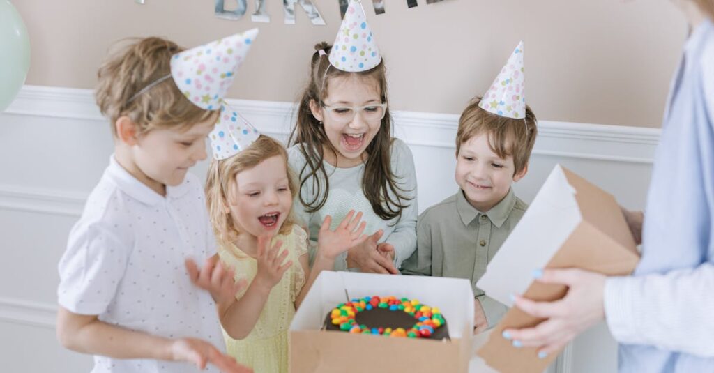 pexels-photo-7600387-7600387 Joyful kids celebrating a birthday with a colorful cake and party hats indoors.