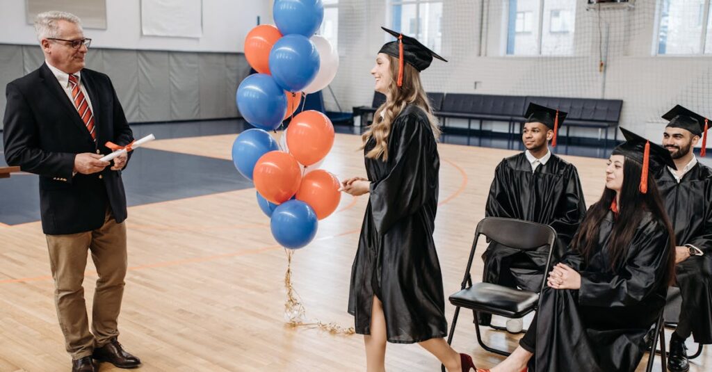 Students in gowns celebrating graduation in a gymnasium setting.