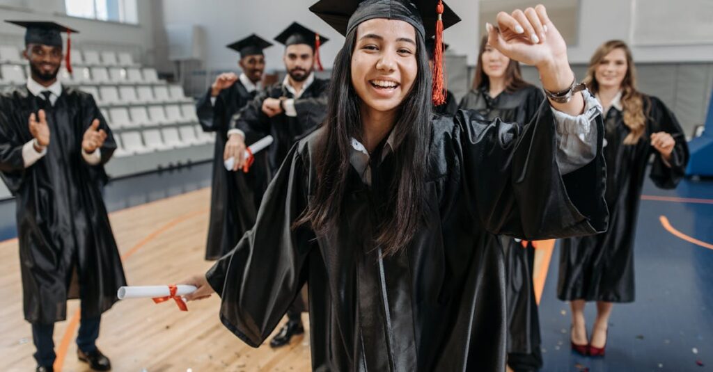Group of graduates celebrating indoors with diplomas, wearing gowns and caps, showcasing happiness and accomplishment.