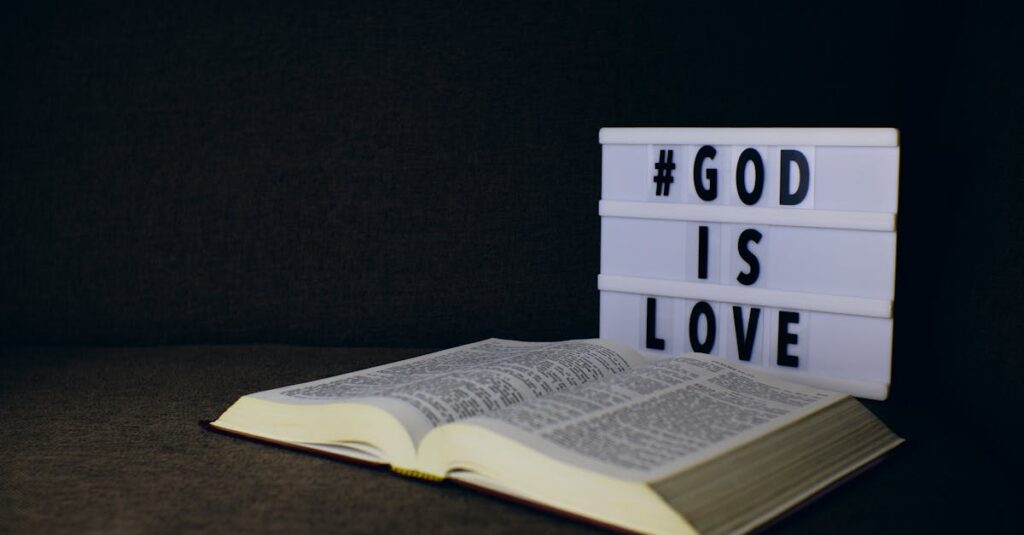 pexels-photo-8274073-8274073 An open Bible next to a lightbox sign displaying the text 'God is Love' on a dark background.