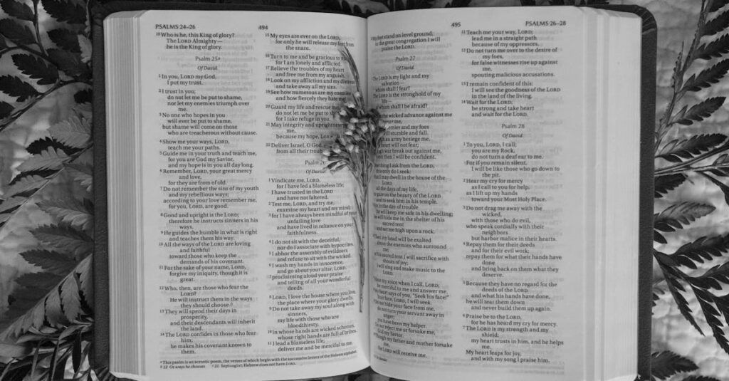 Black and white image of the Bible open to the book of Psalms with ferns around.