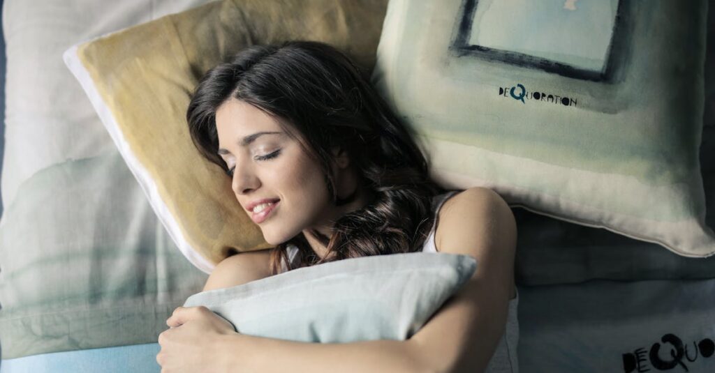 Woman peacefully sleeping in bed, hugging a pillow with a contented smile.