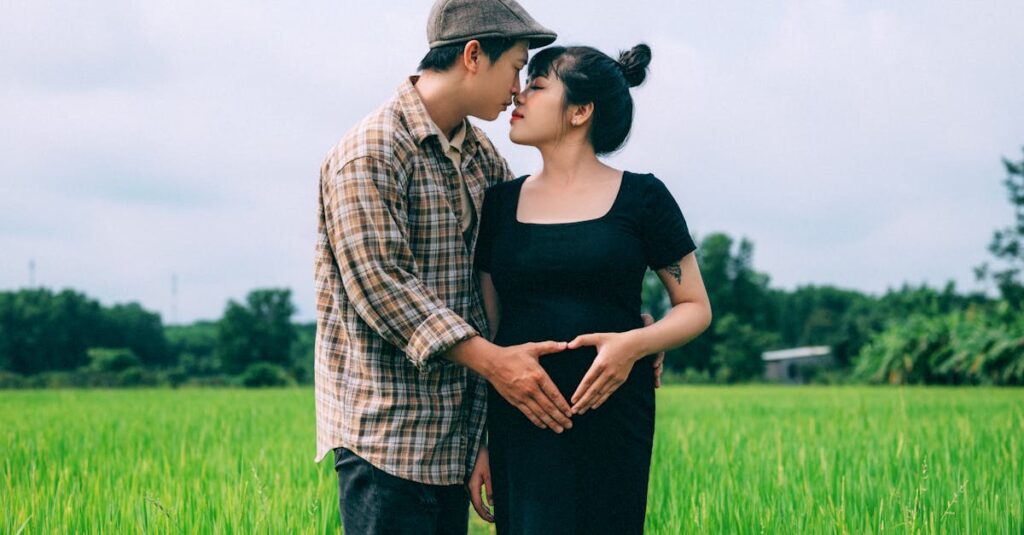 Pregnant couple embracing in a lush green field, symbolizing love and togetherness.