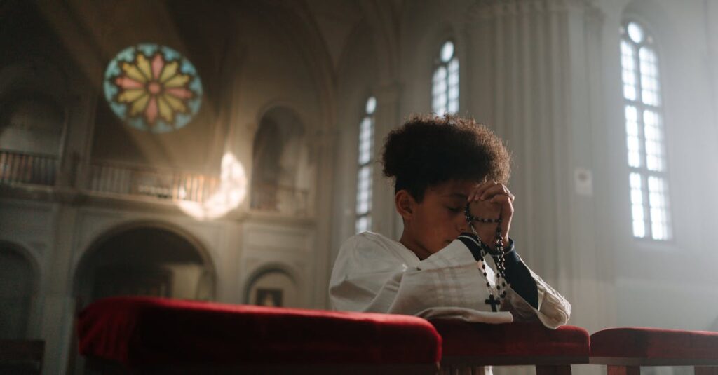 Child praying with rosary in a serene cathedral setting, sunlight through stained glass.