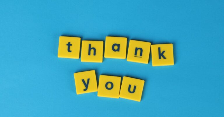 Bright yellow letter tiles spelling 'thank you' on a blue background, perfect for gratitude notes.