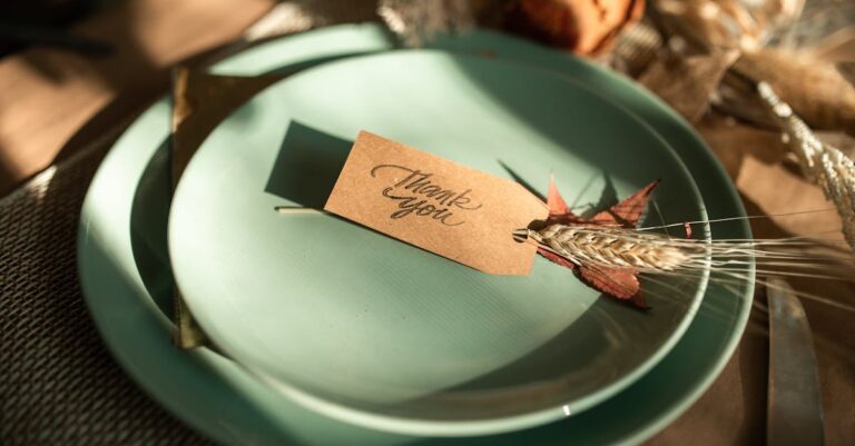 A sophisticated Thanksgiving table setup featuring a 'Thank You' card on mellow green plates, perfect for seasonal celebrations.