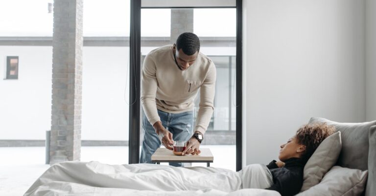 A man cares for his sick wife in bed, bringing her a cup of tea indoors.