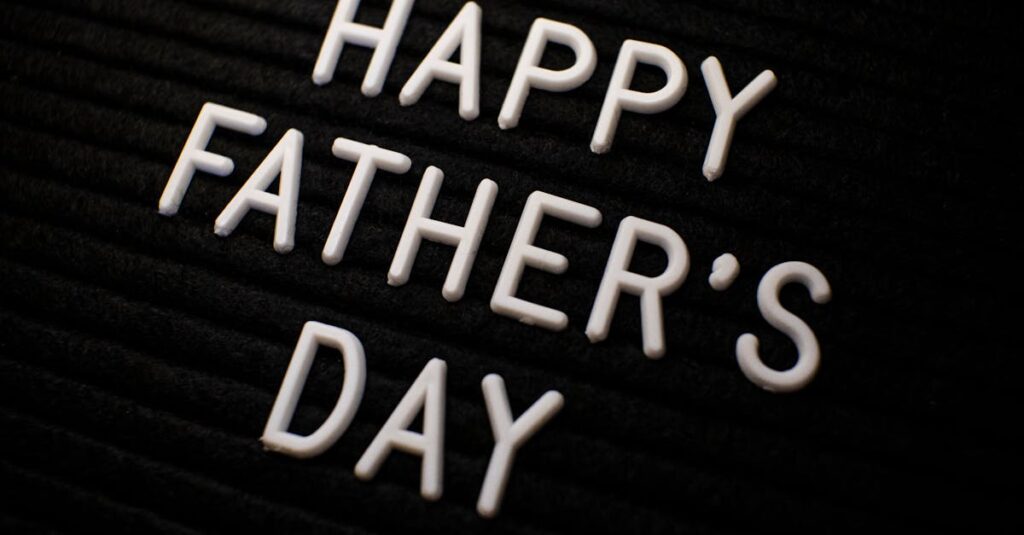 Close-up of 'Happy Father's Day' text in white letters on a black textured background.