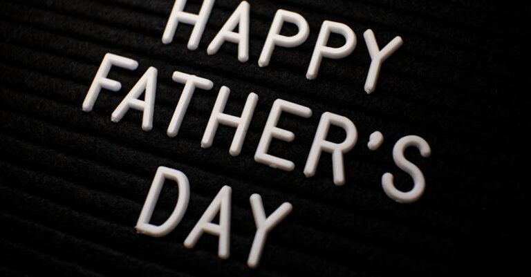 Close-up of 'Happy Father's Day' text in white letters on a black textured background.