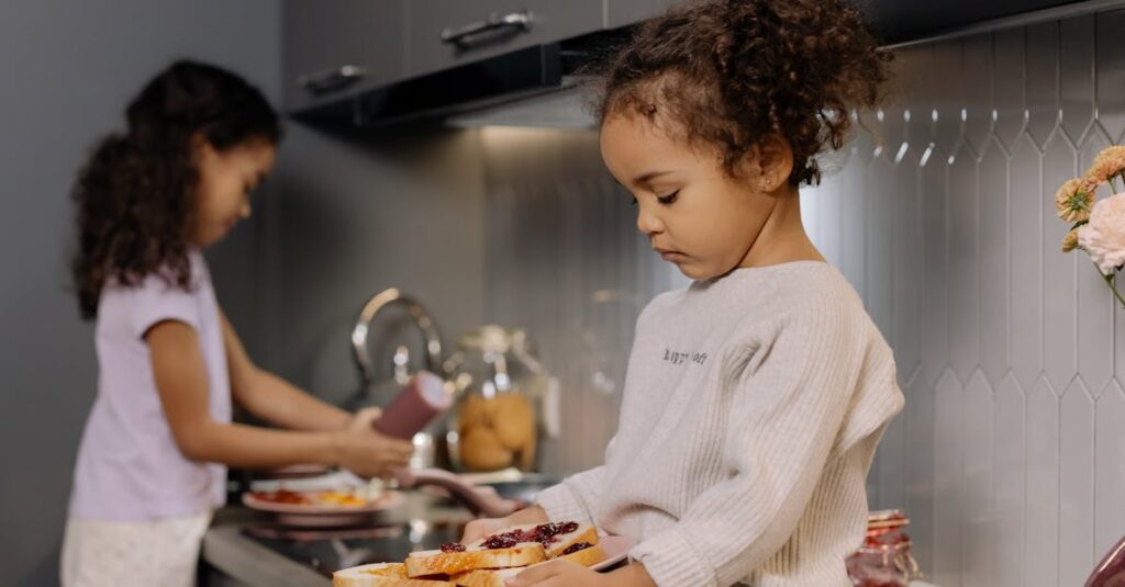 Two young sisters making and enjoying sandwiches in a modern kitchen setting.