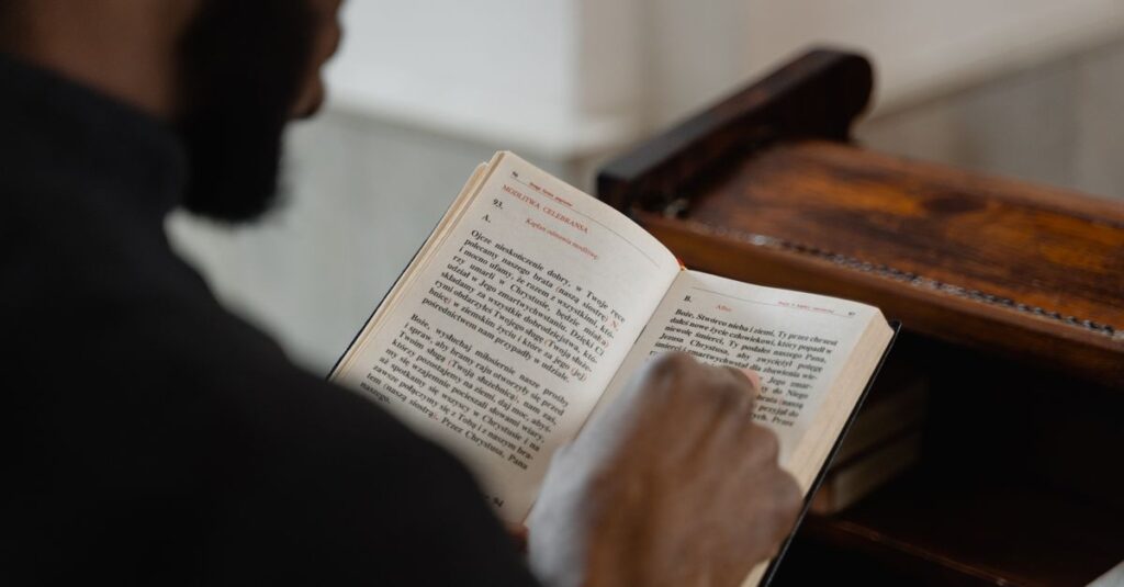 pexels-photo-7219517-7219517 A man reading a religious book inside a church, focusing on a spiritual moment.