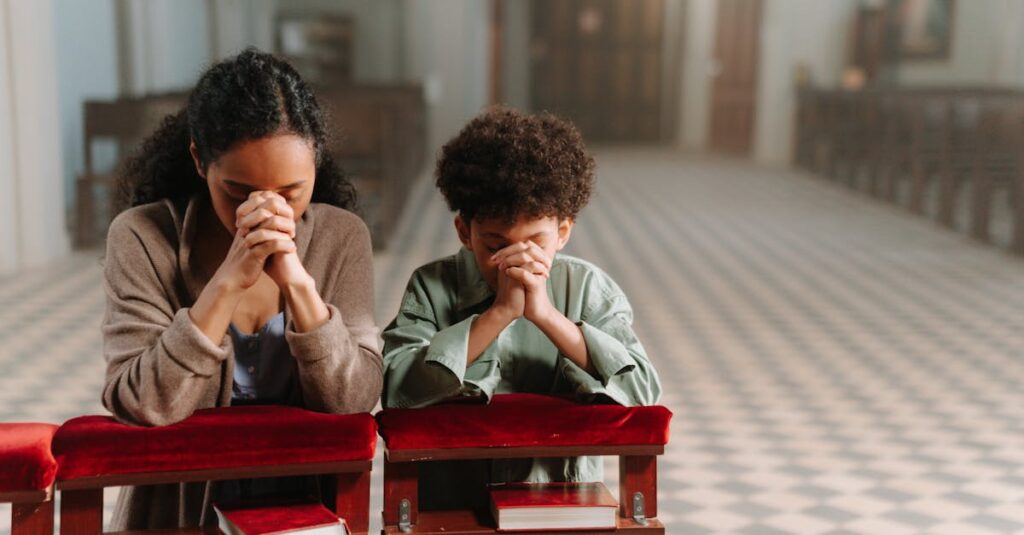 A mother and son kneeling and praying together inside a serene church.