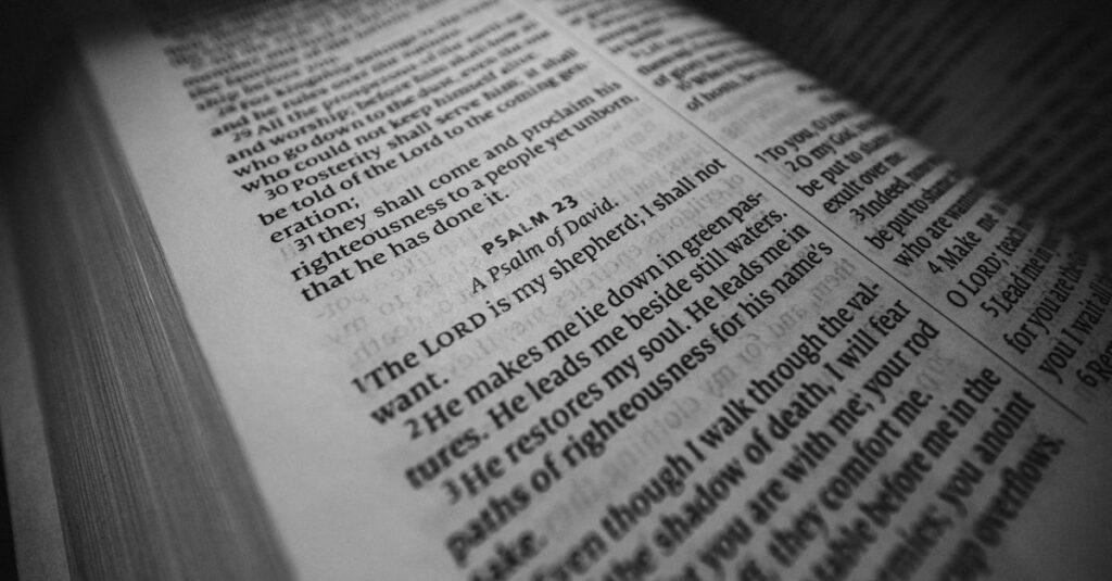 Black and white close-up of Psalm 23 in an open Bible, emphasizing spiritual serenity.