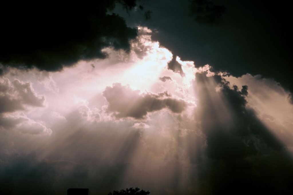 Captivating image of sun rays breaking through dark clouds creating a magnificent skyscape.