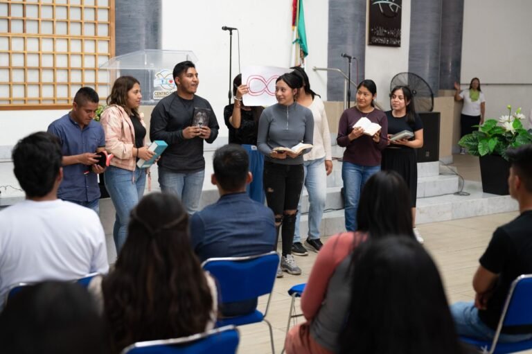 Young adults gather for a religious event at a Mexico City church, reading and participating.