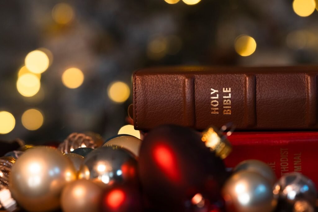 Close-up of a Holy Bible with Christmas ornaments and festive lights, creating a warm holiday ambiance.