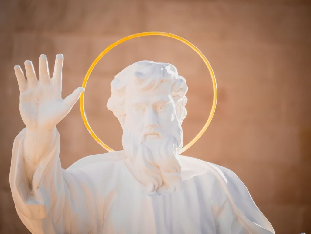 A serene white marble sculpture of a religious saint with a distinct halo, symbolizing peace and divinity.