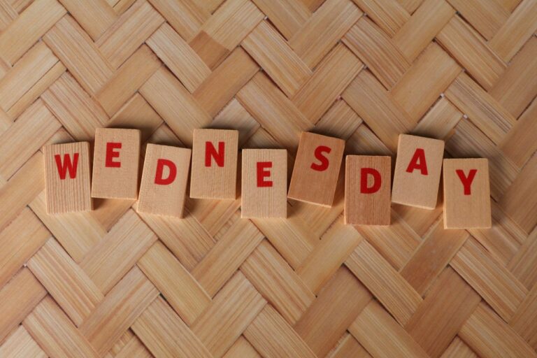 Wooden tiles display 'Wednesday' on a woven texture background, ideal for weekday themes.