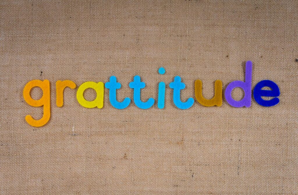 pexels-photo-4116564-4116564 Vibrant colored letters spelling 'gratitude' on a textured burlap surface.