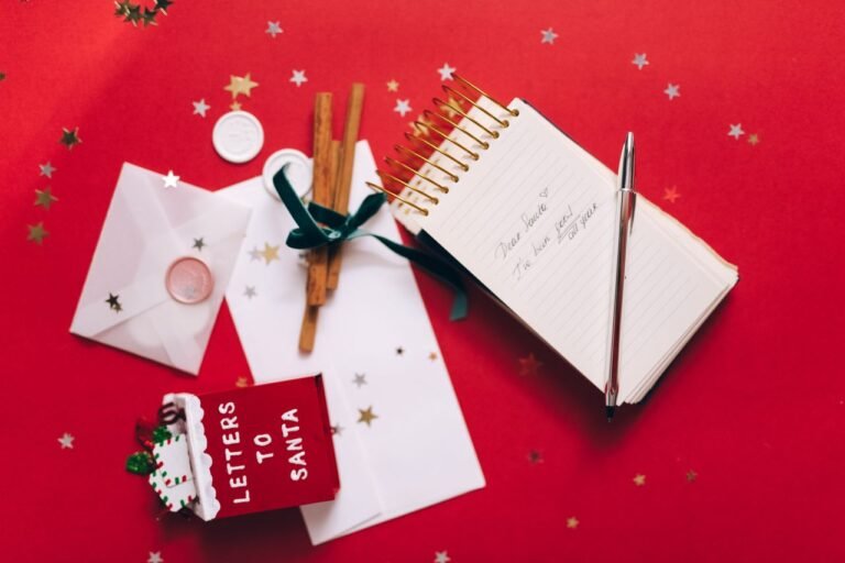 Red and gold themed Christmas flat lay with letter to Santa and decorations.