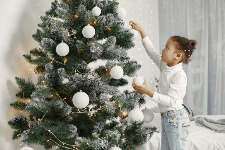Young girl decorating a Christmas tree indoors, emphasizing holiday spirit and joy.