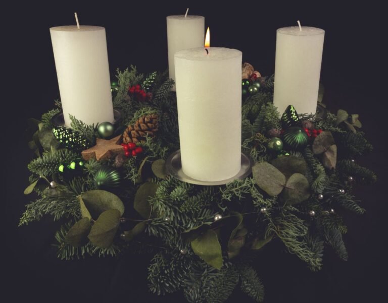 Christmas advent wreath with green foliage, decorated with candles, pinecones, and ornaments.