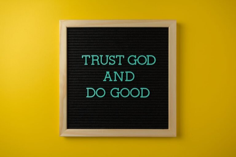 Inspirational message 'Trust God and Do Good' on a stylish black letter board with a vibrant yellow background.